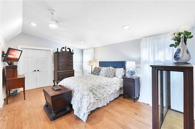 bedroom featuring hardwood / wood-style floors, a closet, and lofted ceiling