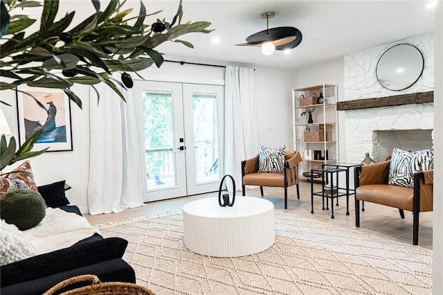 living area featuring light hardwood / wood-style floors, a fireplace, and french doors