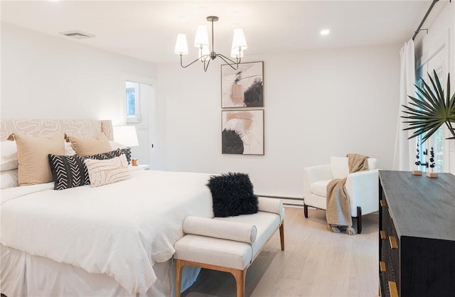 bedroom with a chandelier and light hardwood / wood-style floors