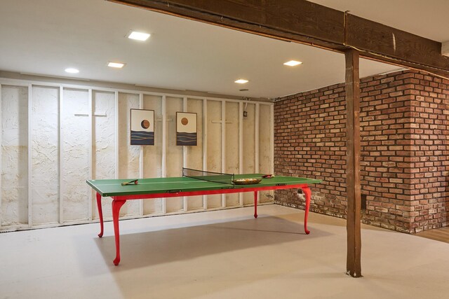 game room with brick wall and concrete floors