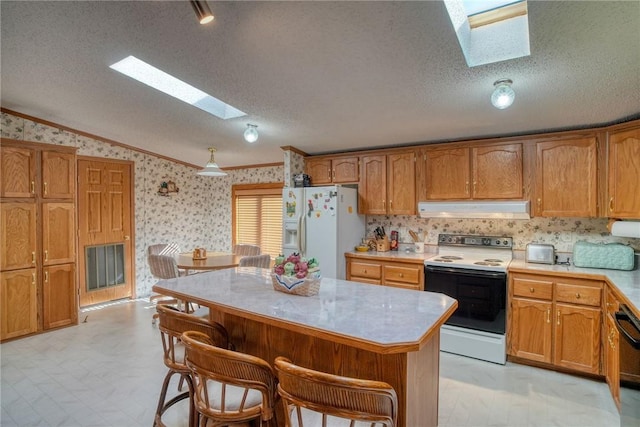 kitchen with vaulted ceiling with skylight, a kitchen island, white appliances, and a textured ceiling