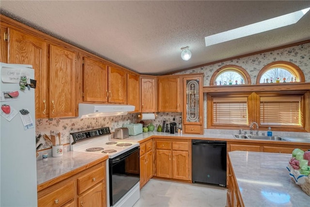 kitchen featuring sink, a textured ceiling, white appliances, and vaulted ceiling with skylight