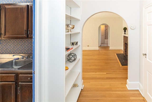 hallway featuring sink and light hardwood / wood-style flooring