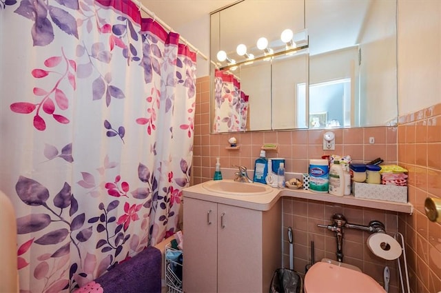 bathroom with a shower with curtain, vanity, tile walls, and toilet