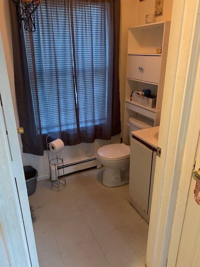 bathroom with baseboard heating, tile patterned flooring, vanity, and toilet