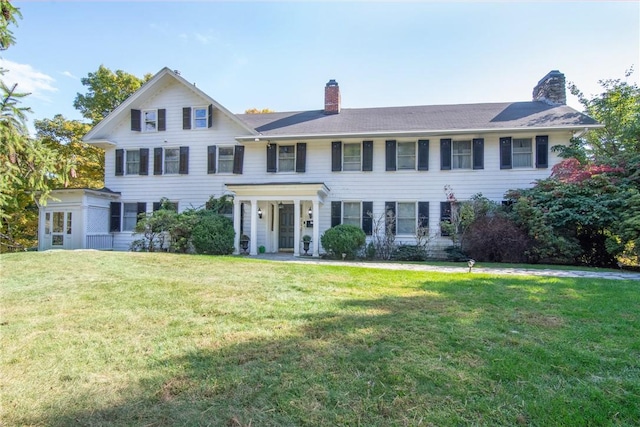 colonial-style house featuring a front lawn