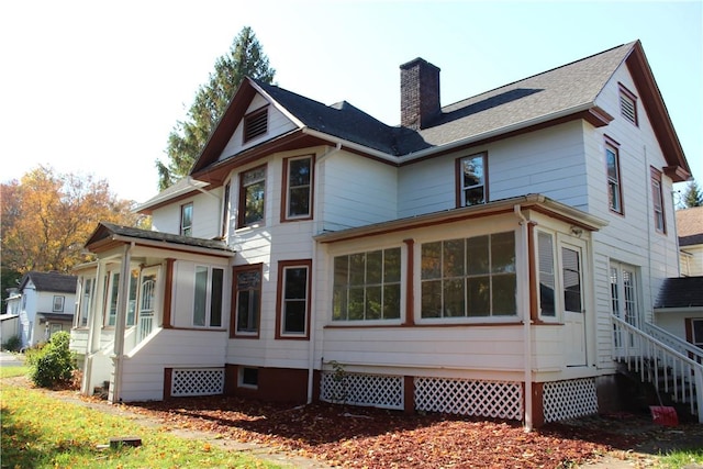 rear view of house featuring a sunroom