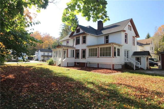 rear view of property featuring a lawn