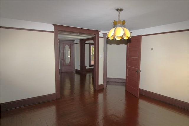 unfurnished dining area with decorative columns and dark wood-type flooring