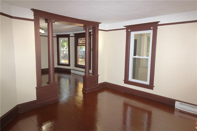 spare room with dark hardwood / wood-style floors and ornate columns