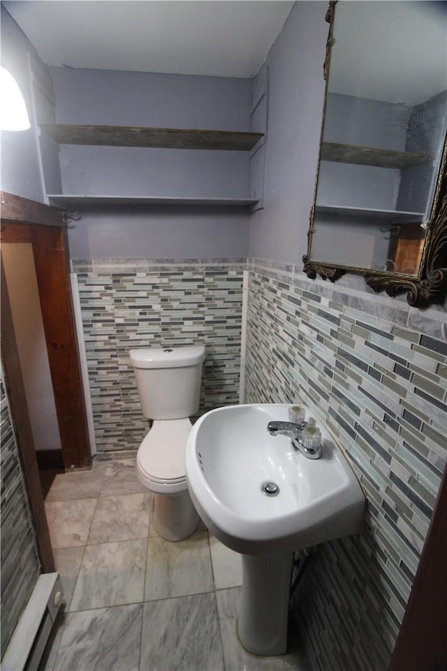 bathroom featuring tile walls and toilet