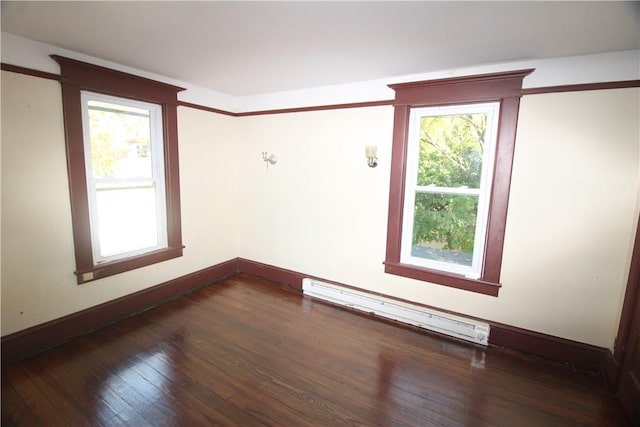 unfurnished room with baseboard heating, a wealth of natural light, and dark hardwood / wood-style flooring