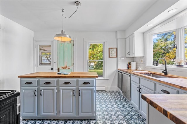 kitchen featuring stainless steel dishwasher, plenty of natural light, butcher block counters, and sink