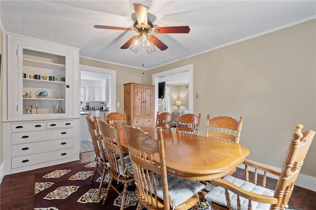 dining area with ceiling fan, dark wood-type flooring, and ornamental molding