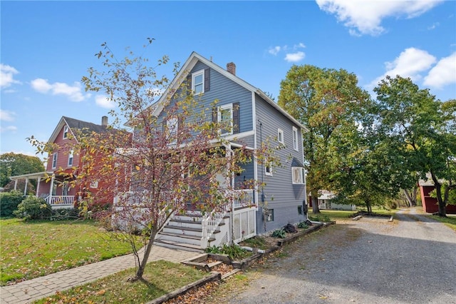 view of front of home with covered porch and a front lawn