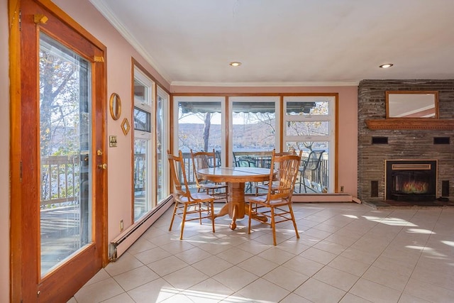 tiled dining space with a fireplace, baseboard heating, and ornamental molding