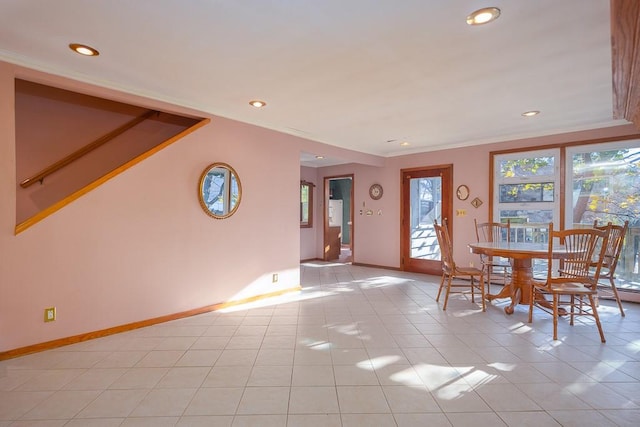 unfurnished dining area featuring crown molding and light tile patterned flooring