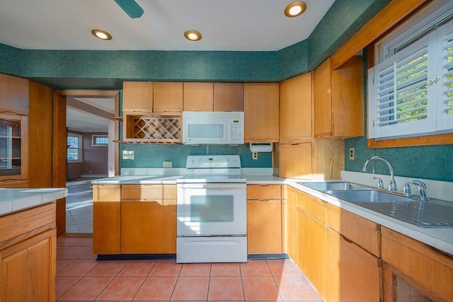 kitchen with sink, white appliances, and light tile patterned flooring