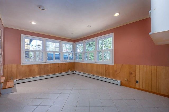 unfurnished room featuring ornamental molding, wooden walls, and a baseboard heating unit