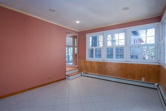 tiled empty room with crown molding, wooden walls, and a baseboard radiator