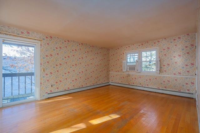 unfurnished room with cooling unit, wood-type flooring, and a baseboard radiator