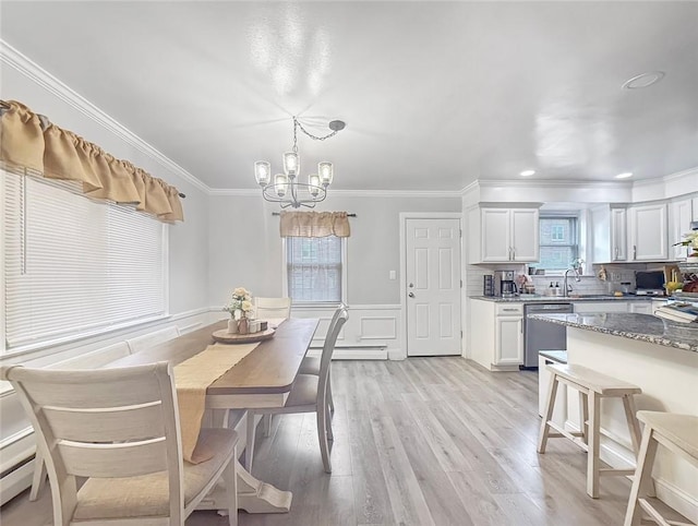 dining area with sink, ornamental molding, a baseboard radiator, a notable chandelier, and light hardwood / wood-style floors