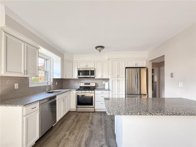 kitchen featuring wood-type flooring, appliances with stainless steel finishes, white cabinetry, and sink