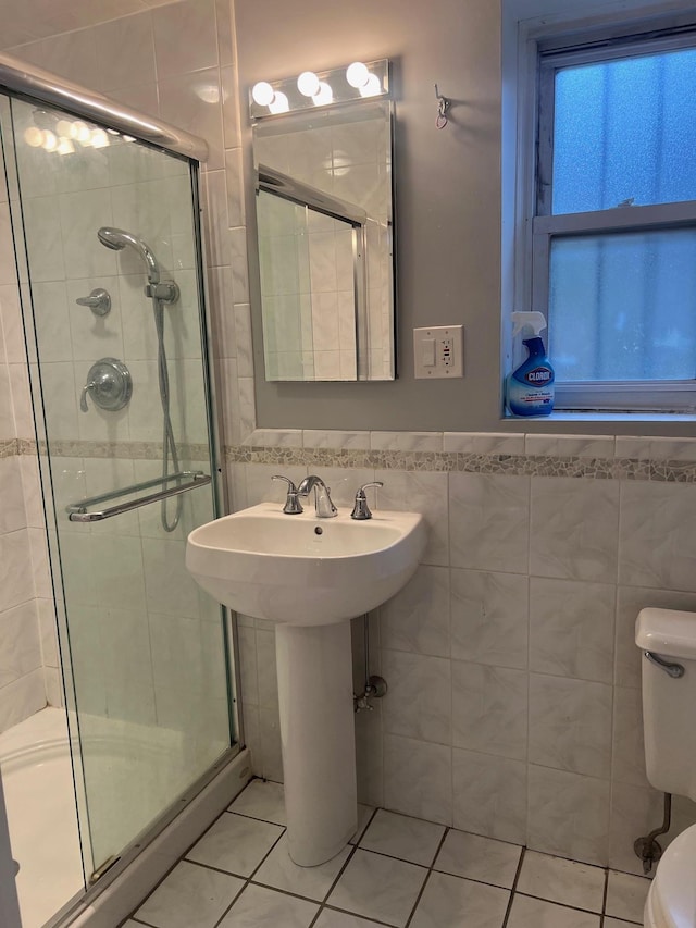 bathroom featuring tile patterned floors, an enclosed shower, tile walls, and toilet