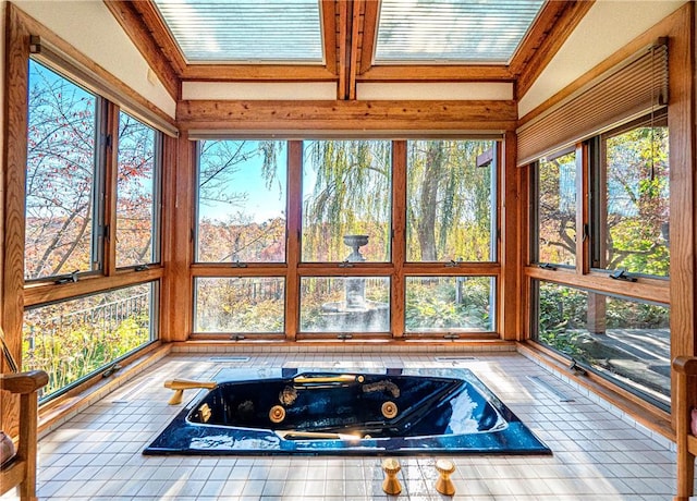 unfurnished sunroom with lofted ceiling, a healthy amount of sunlight, and a hot tub