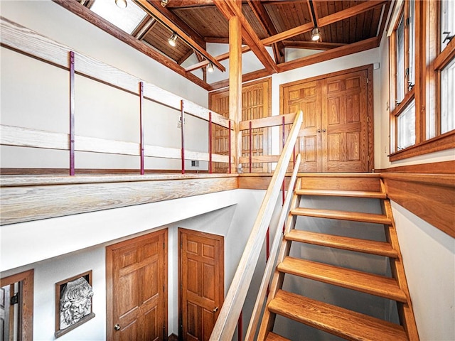 stairs featuring lofted ceiling with beams and wooden ceiling