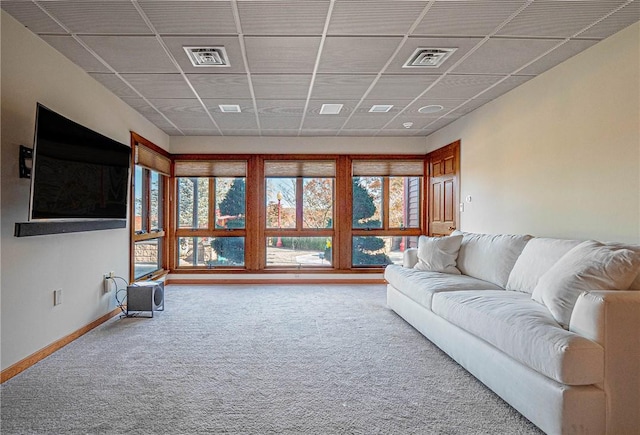 living room featuring a paneled ceiling and carpet floors