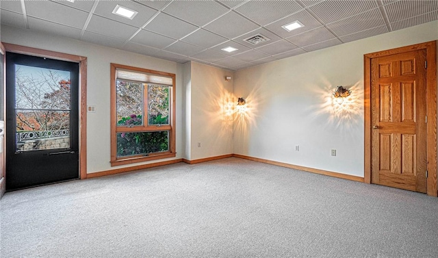 carpeted empty room featuring a paneled ceiling