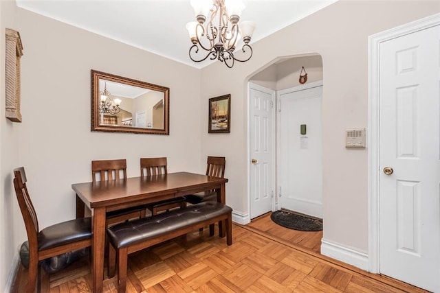 dining room featuring light parquet floors and an inviting chandelier