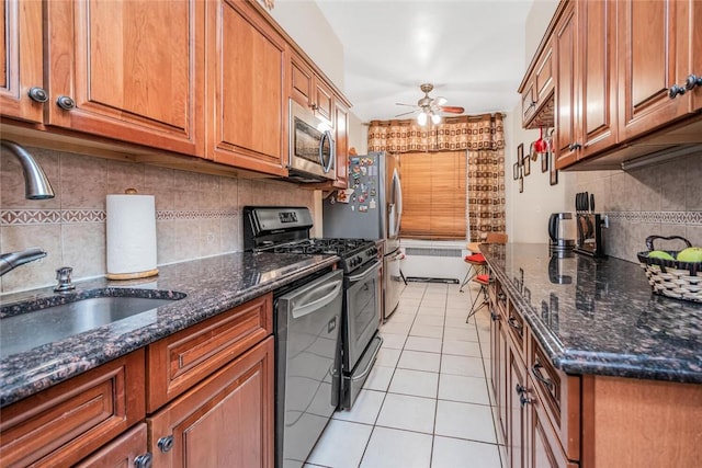 kitchen featuring appliances with stainless steel finishes, tasteful backsplash, ceiling fan, sink, and light tile patterned floors