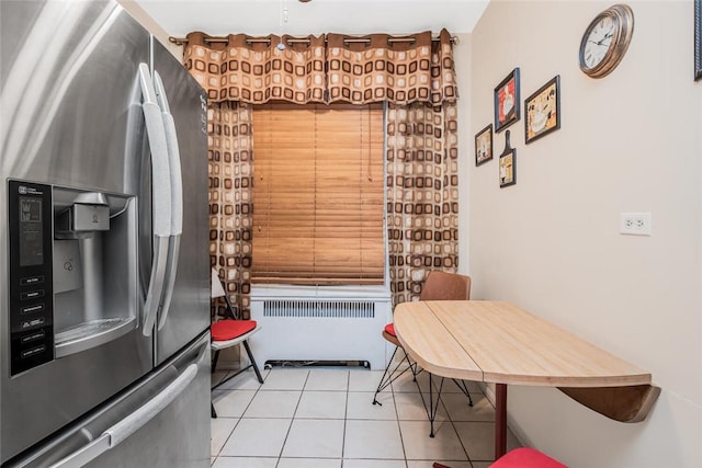 kitchen with radiator, stainless steel fridge with ice dispenser, and light tile patterned flooring