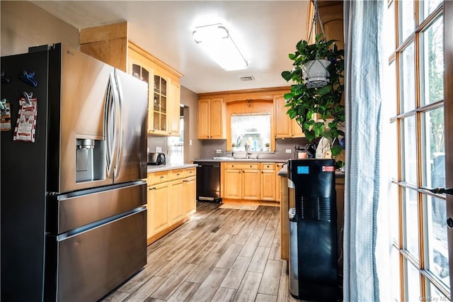 kitchen with a wealth of natural light, dishwasher, light hardwood / wood-style flooring, stainless steel refrigerator with ice dispenser, and light brown cabinetry