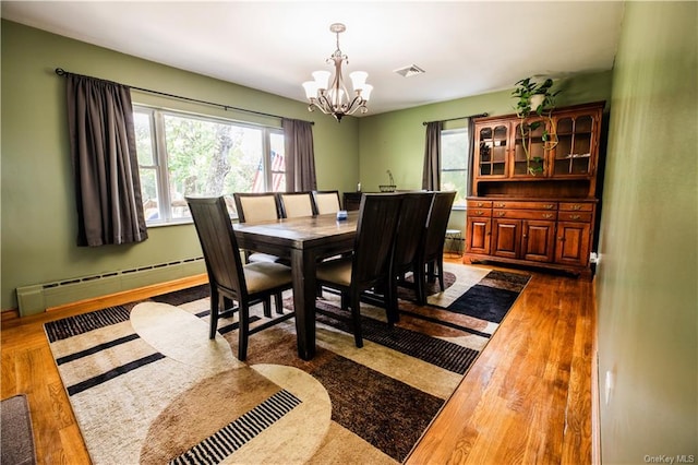 dining space featuring a notable chandelier, dark hardwood / wood-style flooring, and baseboard heating