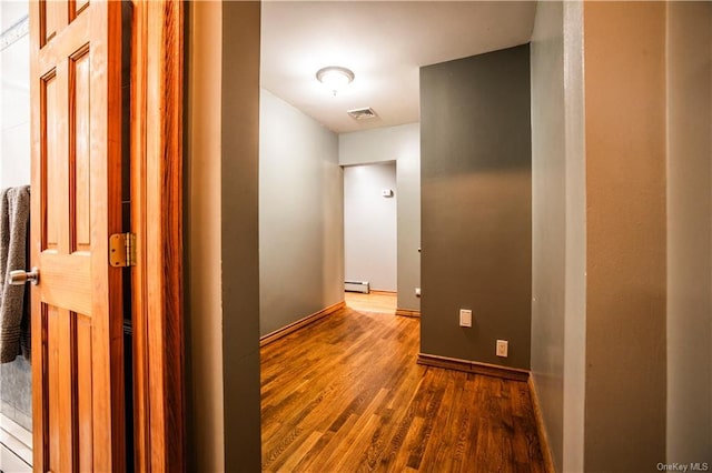 hallway featuring wood-type flooring and a baseboard radiator