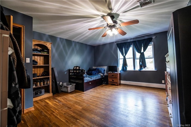 bedroom featuring ceiling fan, a baseboard radiator, and wood-type flooring