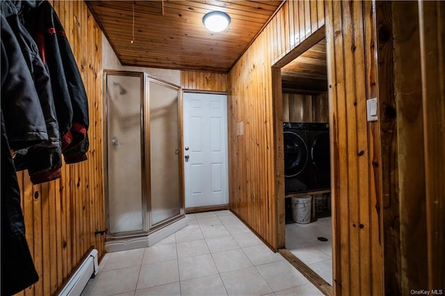 interior space with separate washer and dryer, wooden walls, light tile patterned floors, and wooden ceiling