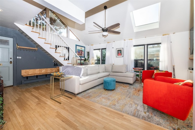 living room featuring high vaulted ceiling, a skylight, ceiling fan, beamed ceiling, and wood-type flooring