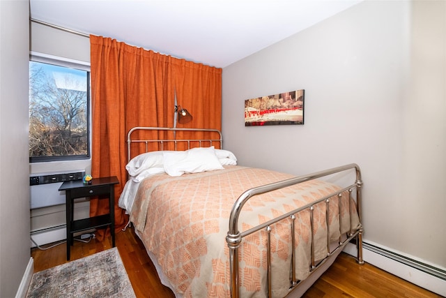 bedroom with baseboard heating and dark wood-type flooring