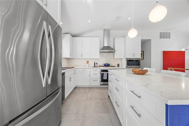 kitchen with a center island, wall chimney exhaust hood, hanging light fixtures, backsplash, and appliances with stainless steel finishes