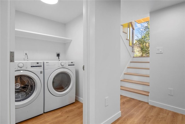 clothes washing area with independent washer and dryer and light hardwood / wood-style flooring