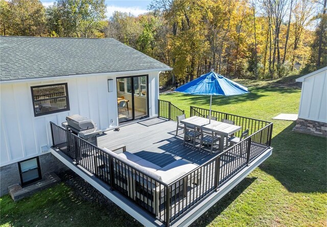 wooden deck featuring a yard and a grill