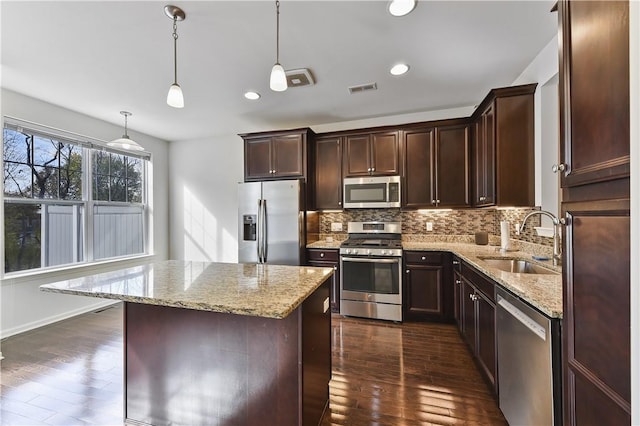 kitchen with sink, hanging light fixtures, dark hardwood / wood-style flooring, a kitchen island, and appliances with stainless steel finishes