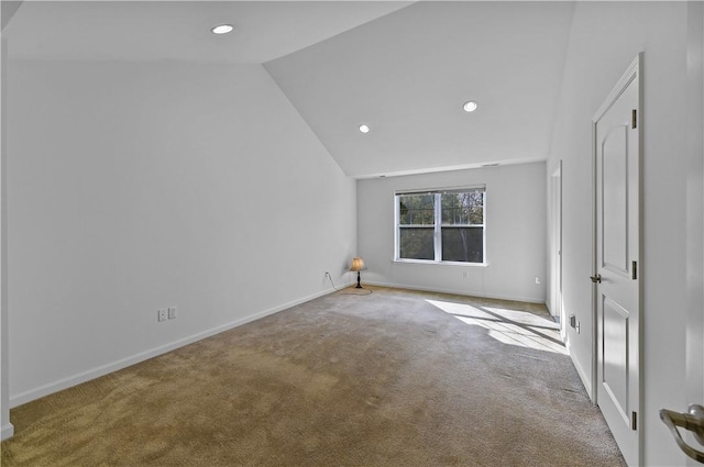 unfurnished room featuring light carpet and vaulted ceiling