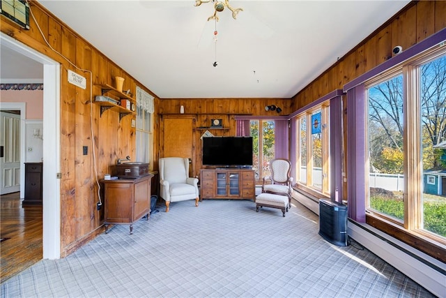 interior space with wood walls, crown molding, light wood-type flooring, and baseboard heating