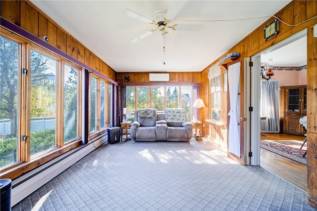 unfurnished sunroom with baseboard heating, ceiling fan, and a healthy amount of sunlight