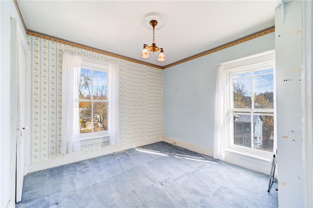 unfurnished dining area with carpet flooring, an inviting chandelier, and ornamental molding